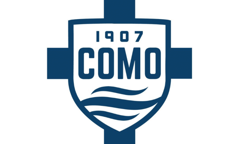 Logo of Como 1907, featuring a blue-and-white shield with the text “1907 COMO” and stylized wave lines representing Lake Como.